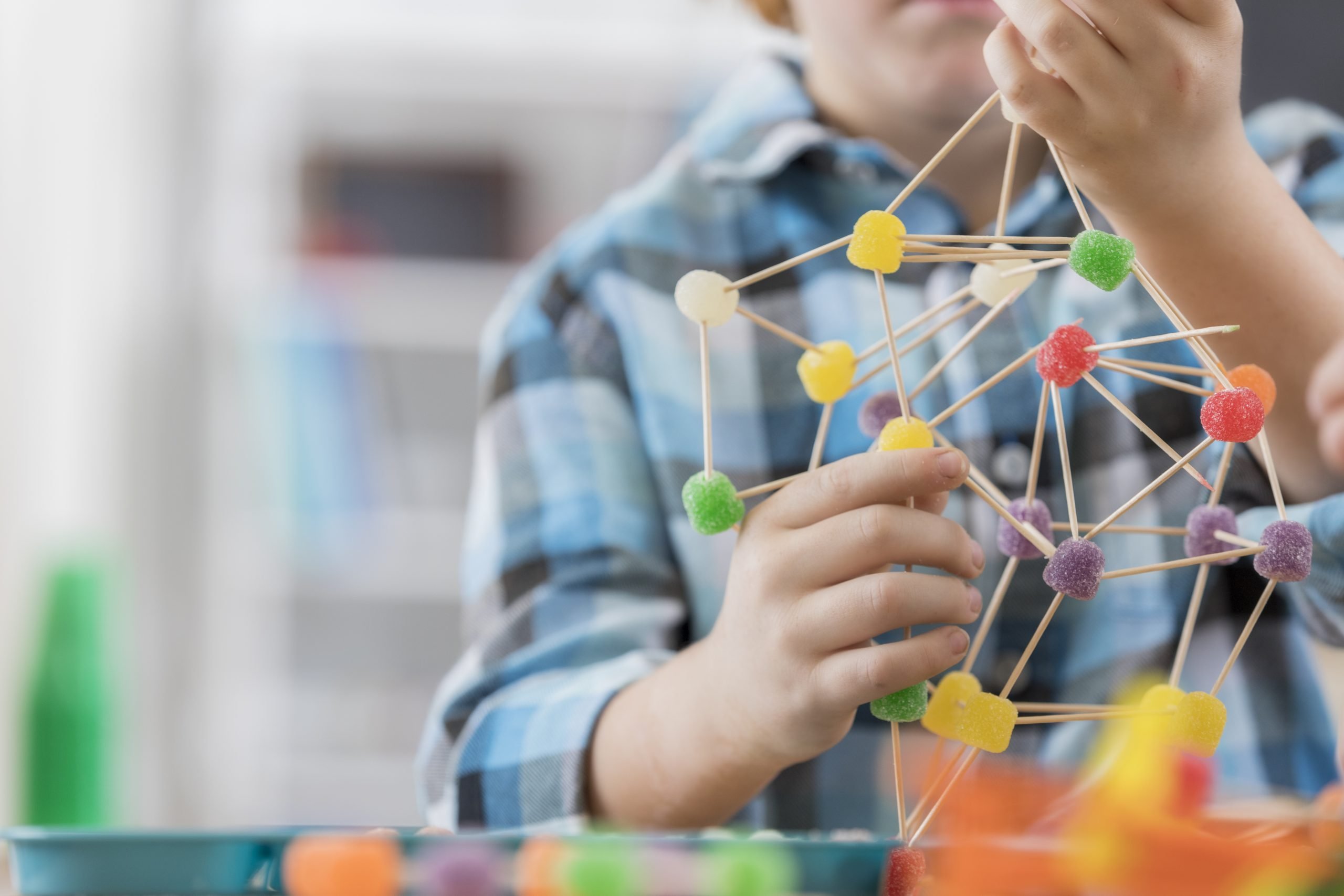 Boy creates something from toothpicks and gum drop candy